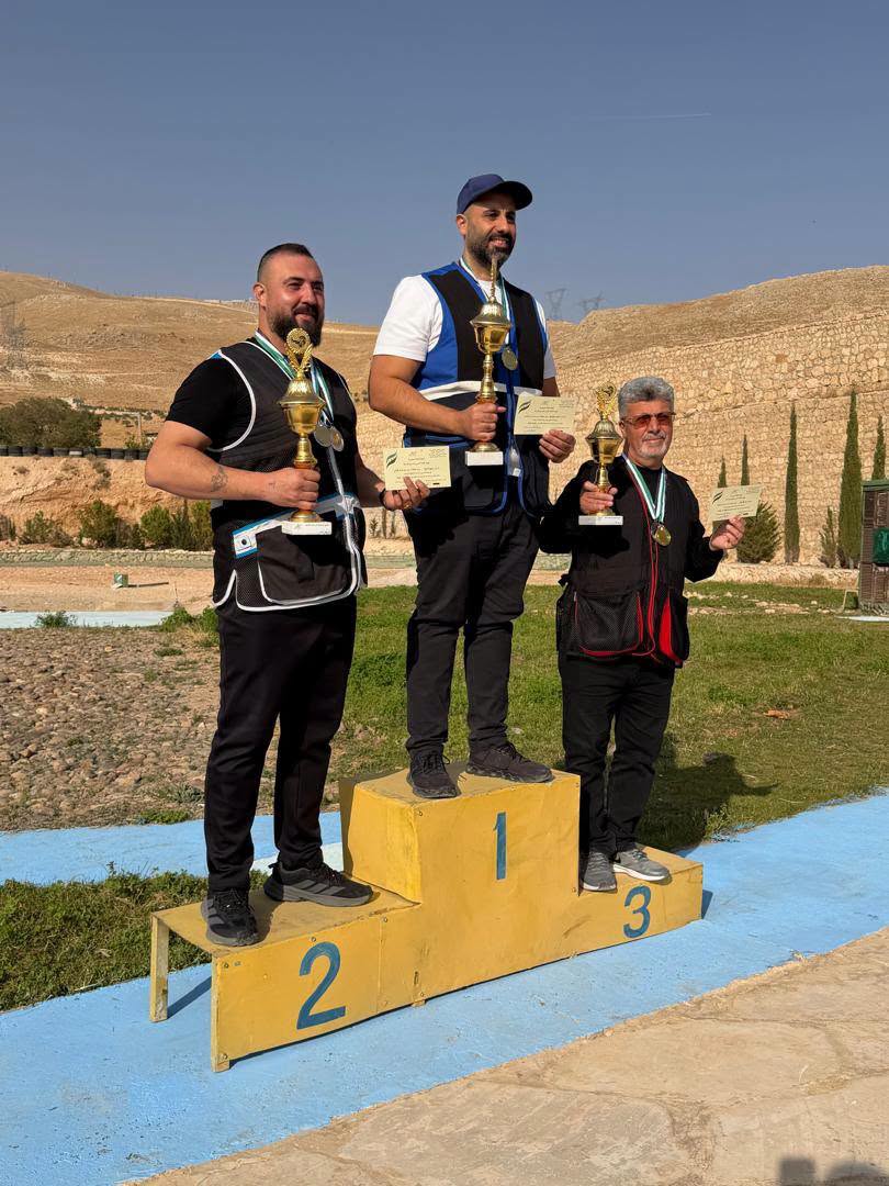 ثلاثة متوجين يحملون الكؤوس والميداليات على منصة بطولة الجمهورية في صيدنايا.